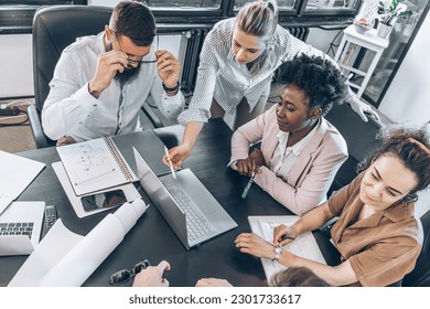 A diverse, casual design team collaborates in the office, creating innovative solutions and fostering in dynamic creative environment. - Powered by Shutterstock