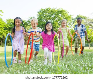 Diverse Children Playing With Hula Hoops In The Park