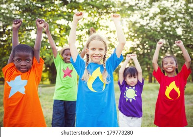 Diverse Children Playing Super Heroes In The Park