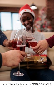 Diverse Colleagues Clinking Glasses Of Wine At Office Event, Doing Cheers Sign With Alcohol To Celebrate Christmas Eve Festivity. Coworkers Toasting With Alcoholic Drink At Holiday Party. Close Up.