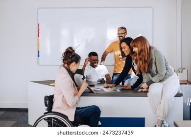 Diverse colleagues gathered in the office having fun while discussing new ideas for their new project. Multiracial coworkers gathered at the table while exchanging ideas at briefing. Copy space. - Powered by Shutterstock