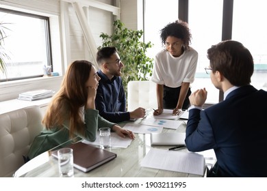 Diverse colleagues working with financial documents, project statistics in boardroom together, African American team leader holding briefing, employees team brainstorming, discussing startup ideas - Shutterstock ID 1903211995