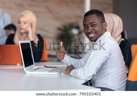 diverse college students using laptop and talking, learning exchanging ideas
