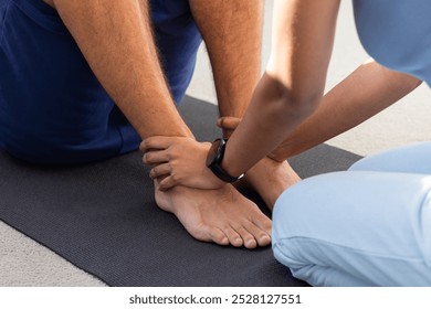 Diverse couple exercising together on yoga mat. Natural light streaming through large windows in a bright room, creating a serene atmosphere, unaltered - Powered by Shutterstock