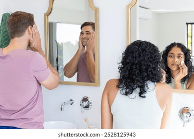 Diverse couple getting ready in front of bathroom mirrors. Bright, modern bathroom with natural light streaming through windows, unaltered - Powered by Shutterstock