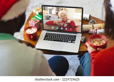 Diverse couple having christmas video call with senior caucasian woman. Communication technology and christmas, digital composite image. - Powered by Shutterstock