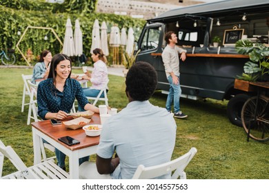 Diverse couple having lunch near food truck in park - Powered by Shutterstock