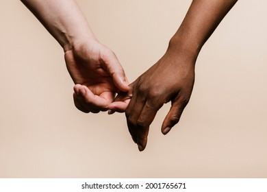 Diverse couple holding hands closeup - Powered by Shutterstock