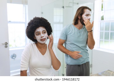 Diverse couple standing in bathroom wearing beauty masks. staying at home in isolation during quarantine lockdown. - Powered by Shutterstock