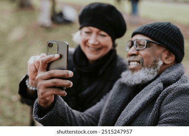 Diverse couple taking selfie in the park  - Powered by Shutterstock