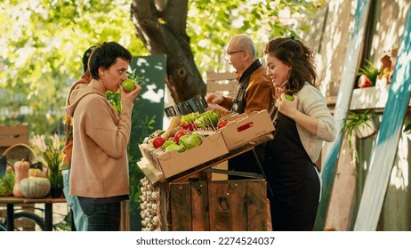 Diverse couple visiting farmers market counter with vendors, looking to buy homegrown fresh bio products from street fair. Man and woman shopping for organic vegetables at greenmarket. - Powered by Shutterstock