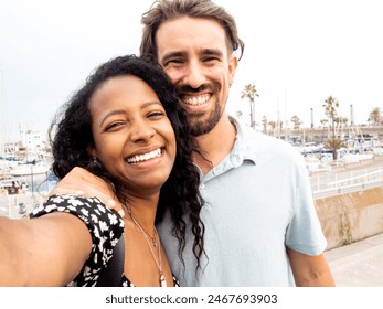 Diverse couple of young happy lovers taking a selfie during vacation - Powered by Shutterstock