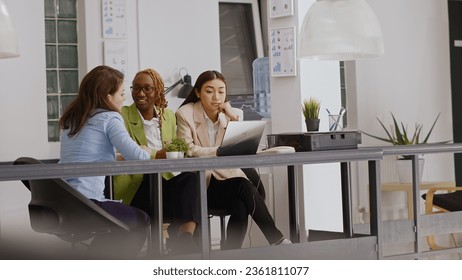 Diverse coworkers analyzing statistics on papers and pc screen, showing executive data report in briefing meeting. People doing teamwork discussing about new development strategy. Handheld shot. - Powered by Shutterstock