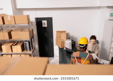 Diverse coworkers discussing merchandise packaging details before start working at customers orders in warehouse. Stockroom employees planning merchandise inventory, analyzing products checklist - Powered by Shutterstock