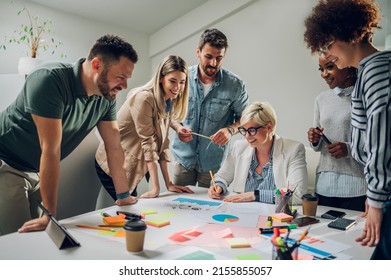 Diverse creative business team working together around a laptop in the meeting room of a modern company. Brainstorming concept. Office life. Multiracial colleagues. - Powered by Shutterstock