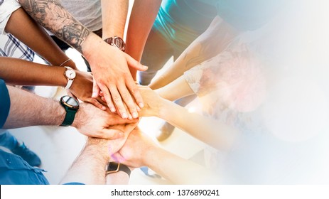Diverse creative team stacking hands - Shutterstock ID 1376890241
