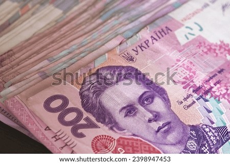 The diverse denominations and colors of Ukrainian Hryvnia banknotes are showcased in this image, featuring a stack of notes, with a specific focus on the two hundred hryvnias denomination.