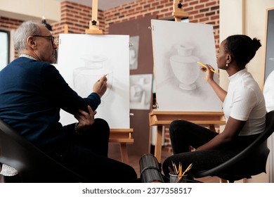 Diverse different aged people students talking during drawing class, senior man and young woman communicating during art course, improving sketching skill. Creative hobbies for adults - Powered by Shutterstock