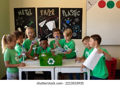 Diverse elementary school being socially concious. Group of schoolchildren wearing green t shirts with a white recycling logo on them  - Powered by Shutterstock