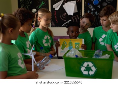 Diverse elementary school being socially concious. Group of schoolchildren wearing green t shirts with a white recycling logo on them  - Powered by Shutterstock