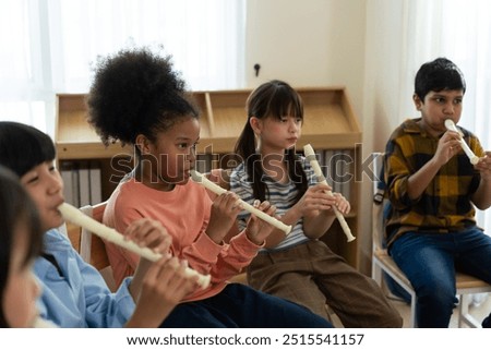 Diverse elementary students practice flutes in vibrant music classroom