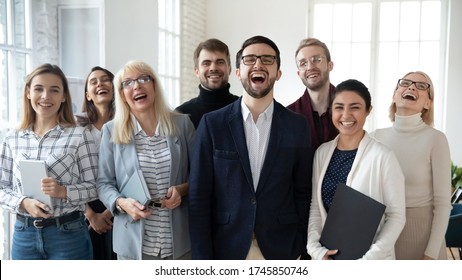 Diverse Emotional Business People Feeling Overjoyed, Laughing, Having Fun Together, Posing For Team Photo In Office. Portrait Of Excited Different Ages Multiracial Teammates Joking At Workplace.