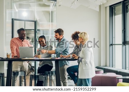 Diverse employees gathered in the office having fun during brainstorming while discussing new ideas for their new project. Multiracial coworkers gather in boardroom discuss ideas in group at briefing.