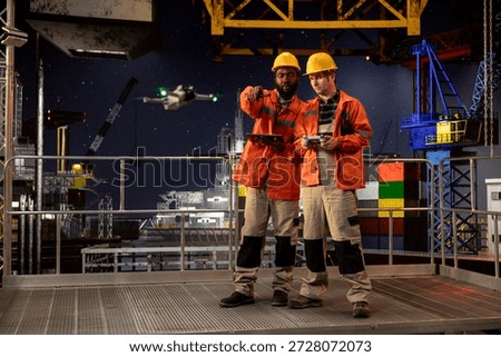 Diverse engineers colleagues using drone for remote operations and aerial mapping on offshore rig, improving logistics, planning and modern maintenance through advanced technology.