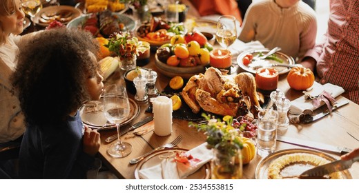 Diverse family enjoying a Thanksgiving festive meal. Laughter and food shared on a table. Thanksgiving celebration with family, delicious and joyful. Diverse family enjoy Thanksgiving meal together - Powered by Shutterstock