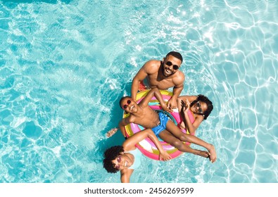 Diverse family enjoys a sunny day in the pool. Smiles radiate as they share a fun and relaxing moment together outdoors. - Powered by Shutterstock