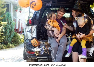 Diverse Family Friends Celebrating Halloween In Car Trunk Outdoors