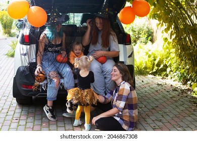 Diverse Family Friends Celebrating Halloween In Car Trunk Outdoors