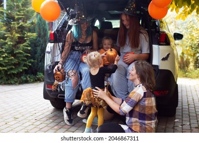 Diverse Family Friends Celebrating Halloween In Car Trunk Outdoors