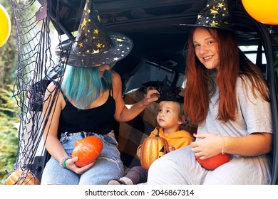 Diverse Family Friends Celebrating Halloween In Car Trunk Outdoors