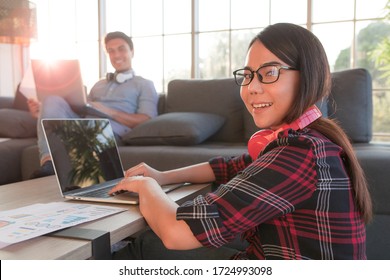 Diverse Family Lovers, Caucasian Man And Asian Woman Couple Using Laptop Computer For Working Or Online Job In House Living Room. Idea For Happily Work From Home Of Modern Business People.