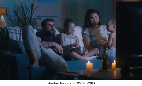 Diverse Family Watching Movie In Dark Living Room