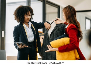 Diverse female fashion designers at work with tailor centimeters on necks and holds tablet and notepad. independent creative design business. 

 - Powered by Shutterstock