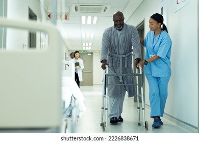 Diverse female healthcare worker helping senior african american male patient use in hospital. Hospital, medical and healthcare services, copy space. - Powered by Shutterstock