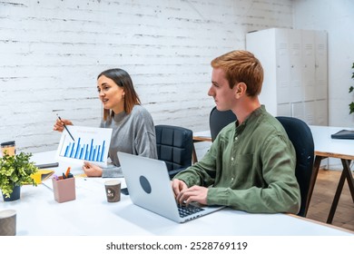 Diverse financial advisors working and analyzing data in a meeting room of a coworking - Powered by Shutterstock