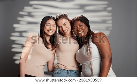 Diverse friends acting cheerful about body acceptance in studio, feeling beautiful and advertising skincare campaign. Young glamorous women smiling on camera and promoting body positivity.