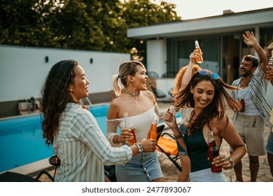 Diverse friends add to the excitement as they join in dancing at the villa pool party - Powered by Shutterstock