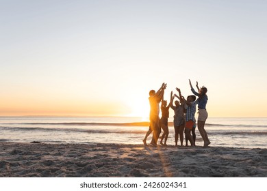 Diverse friends celebrate on the beach at sunset, with copy space. The group's joy is palpable in this outdoor setting. - Powered by Shutterstock