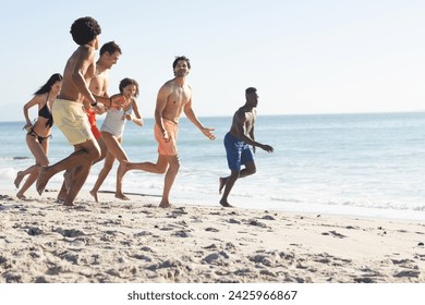 Diverse friends enjoy a lively race on a sunny beach, with copy space. The outdoor setting captures the joy of summer activities by the sea. - Powered by Shutterstock