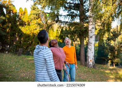 Diverse Friends Playing Badminton Game In The Backyard. Copy Space
