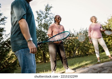 Diverse Friends Playing Badminton Game In The Backyard. Healthy Active Lifestyle