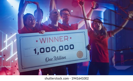 Diverse Gamers Esport Team Winner Of The Video Games Tournament Celebrates Victory Cheering And Holding $1,000,000 Prize Money Presentation Check. Championship Arena Online Streaming Of Cyber Games