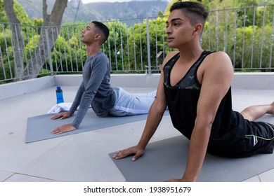 Diverse gay male couple practicing yoga on balcony. staying at home in isolation during quarantine lockdown. - Powered by Shutterstock