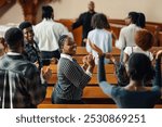 Diverse gospel choir joyfully sings and claps during a religious service led by a passionate priest in a traditional church, showcasing faith, spirituality, and unity