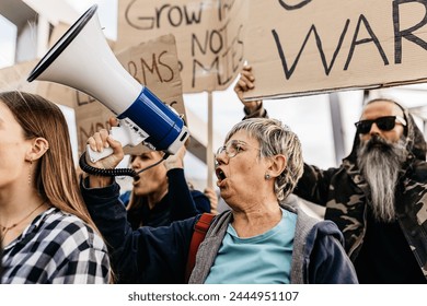 Diverse group of activists people holding posters and banners antiwar protesting against war and violence in the world. - Powered by Shutterstock