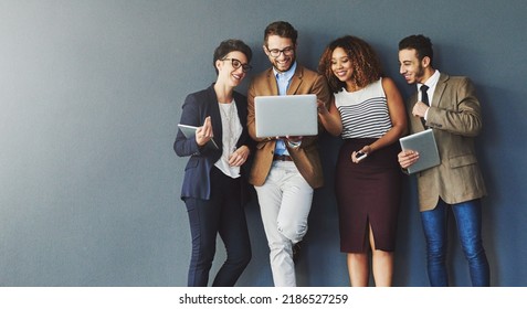 Diverse group of business people with technology browsing, searching and reading positive online reports, data or charts on laptop. Team of creative marketing agents against grey wall with copy - Shutterstock ID 2186527259